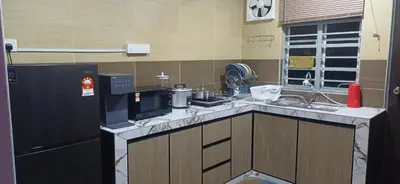 a kitchen with a black refrigerator and a sink at Lavender Splash Homestay in Ipoh
