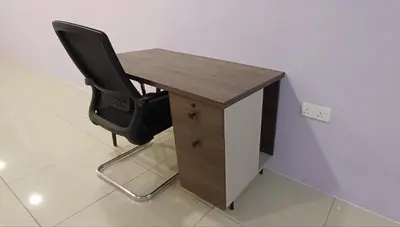 a desk with a black chair next to a wall at Lavender Splash Homestay in Ipoh