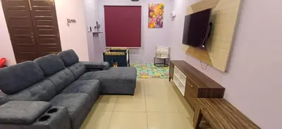 a living room with a couch and a flat screen tv at Lavender Splash Homestay in Ipoh