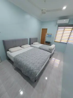 two beds sitting in a room with at Lumut Homestay for Muslims in Lumut