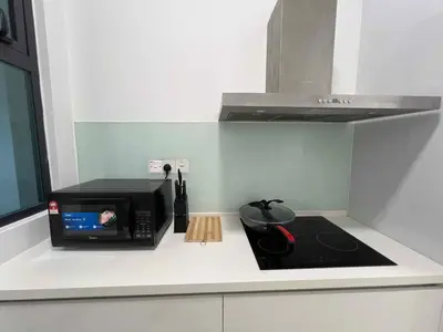 a kitchen counter with a microwave and a stove at High floor Seaview 2BR Jazz Suite Bathtub &Sauna in Tanjong Tokong
