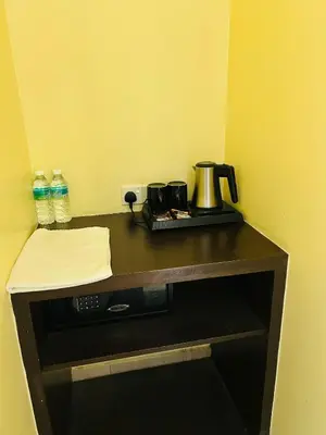 a counter with a coffee maker and water bottles on it at Liner hotel in Simpang