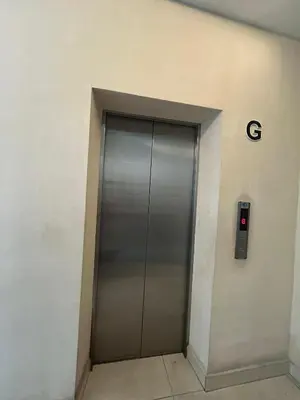a metal elevator door in a building with the letter g at Liner hotel in Simpang
