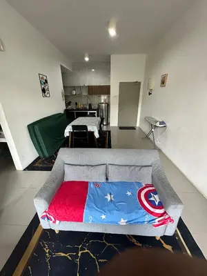a living room with a couch with a blanket on it at Barrington Square Aleysha Homestay Night Market in Brinchang
