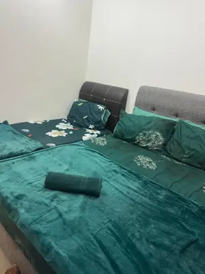 a bed with a green comforter on top of it at Barrington Square Aleysha Homestay Night Market in Brinchang