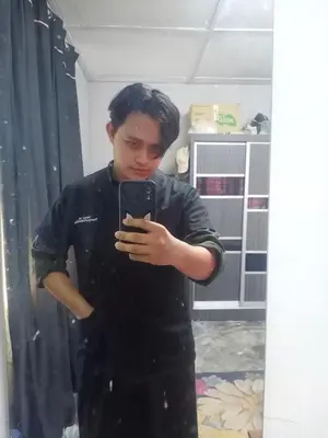 a young man taking a picture of himself in a mirror at Kedah in Padang Serai