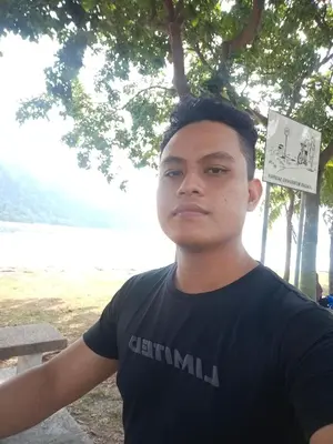 a young man standing in a park with a sign on his head at Kedah in Padang Serai
