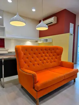an orange couch in a room with a kitchen at Pico City Suite #1BR in George Town