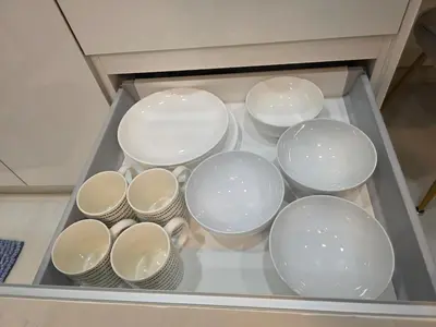 a bunch of plates and bowls in a drawer at Pico City Suite #1BR in George Town