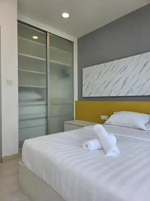a bedroom with a white bed with towels on it at Pico City Suite #1BR in George Town