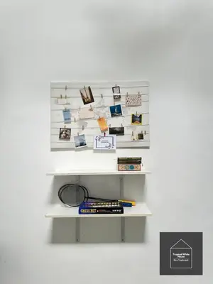 a shelf with photos and books on a wall at Zafirah Ipoh Homestay Musllim Only in Ipoh