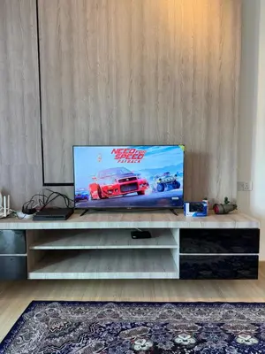 a flat screen tv sitting on top of a entertainment center at AYAAN GAMING CLUB House with PS4 & Table Tennis at Cameron Highland in Tanah Rata