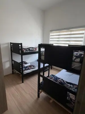 a room with three bunk beds and a window at AYAAN GAMING CLUB House with PS4 & Table Tennis at Cameron Highland in Tanah Rata