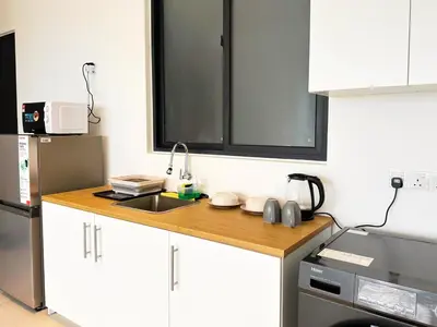 a kitchen with white cabinets and a sink at Urban Seaview, City view, New 3BR 6pax, Jelutong in George Town