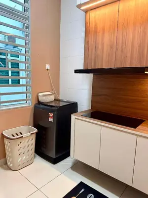 a kitchen with a trash can next to a counter at HOMESTAY Mu in Simpang Ampat