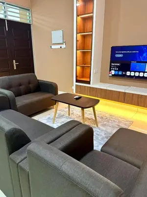 a living room with a couch and a table and a tv at HOMESTAY Mu in Simpang Ampat