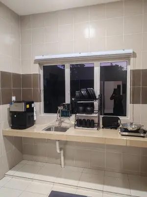 a kitchen counter with a sink and a window at pangkor 71 homestay in Pasir Bogak