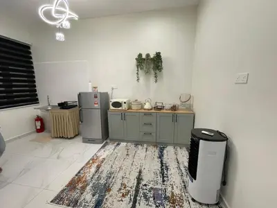 a kitchen with a refrigerator and a counter in a room at Nadine Homestay in Sungai Petani