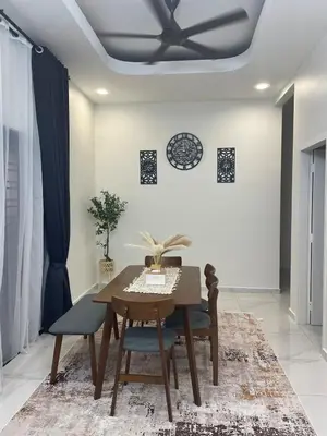 a dining room with a table and a ceiling fan at Nadine Homestay in Sungai Petani