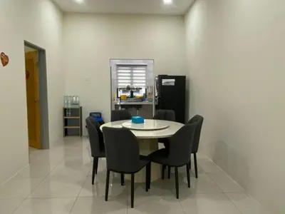 a dining room with a table and chairs and a refrigerator at 96 HomeStay Sungai Besar in Sungai Besar
