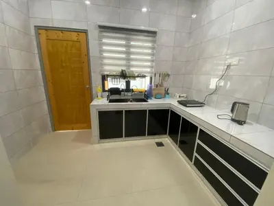 a white kitchen with a counter and a sink at 96 HomeStay Sungai Besar in Sungai Besar