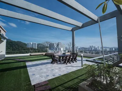 a patio with a table and benches on a roof at 22 Penthouse by BRB, Airport View & 18 Pax in Bayan Lepas