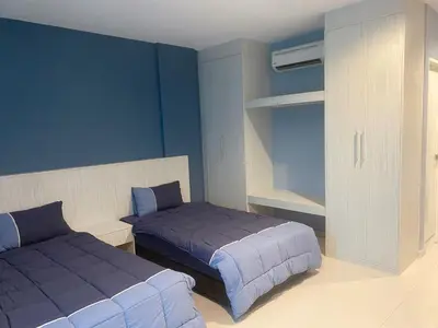 a bedroom with two beds with blue walls and a closet at IRONMAN HomeStay in Lumut
