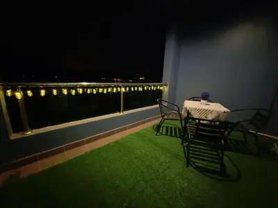 a table and chairs on a balcony at night at IRONMAN HomeStay in Lumut