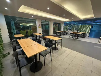 a restaurant with tables and chairs in a room at IRONMAN HomeStay in Lumut