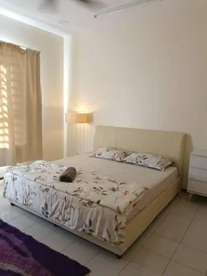 a bedroom with a bed with a cat laying on it at Homestay Bajet EM3 Pantai Damai 2 in Pantai Remis