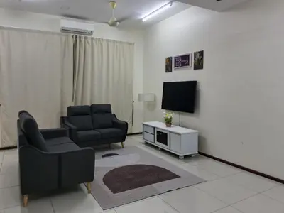 a living room with two chairs and a television at Homestay Bajet EM3 Pantai Damai 2 in Pantai Remis
