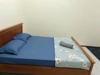 a bed with blue sheets and blue pillows at Homestay Bajet EM3 Pantai Damai 2 in Pantai Remis