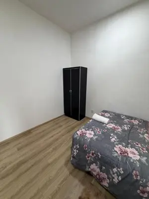 a bedroom with a bed and a black cabinet at AYAAN ATRIUM Homestay with PS4 GAMING and Snookers in Tanah Rata