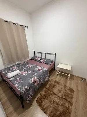 a bedroom with two beds and a rug and a table at AYAAN ATRIUM Homestay with PS4 GAMING and Snookers in Tanah Rata