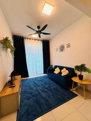 a living room with a blue couch and a ceiling fan at KoopJiha Homestay Meru Ipoh in Ipoh