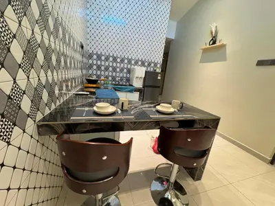 a kitchen with a counter with two chairs and a table at New PRMO !!! Ipoh Staycation Homefeel 50