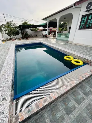 a swimming pool with two yellow inflatables in it at Homestay Laman Kasih Mama in Seri Manjung
