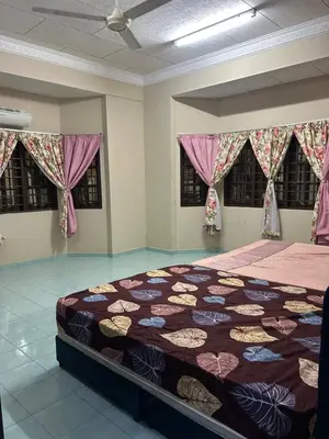 a bedroom with a bed with a quilt on it at Homestay Laman Kasih Mama in Seri Manjung