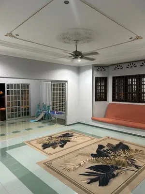 a living room with a ceiling fan and a rug at Homestay Laman Kasih Mama in Seri Manjung