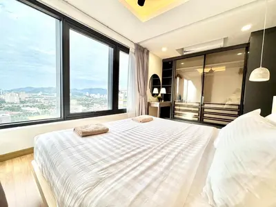 a bedroom with a large bed with large windows at French Vintage Luxury 2BR Suites at Georgetown in George Town