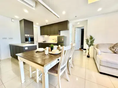 a kitchen and living room with a wooden table and chairs at French Vintage Luxury 2BR Suites at Georgetown in George Town