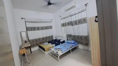 a room with two beds and a mirror in it at Sakeena Homestay in Padang Serai