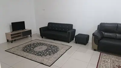 a living room with a couch and a chair and a table at Sakeena Homestay in Padang Serai