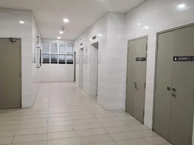 a hallway with white tile floors and doors in a building at Barrington Square Apartment Pasar Malam in Brinchang