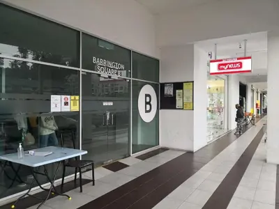 a person walking in a shopping mall with a table at Barrington Square Apartment Pasar Malam in Brinchang