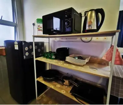 a microwave sitting on top of a shelf in a kitchen at Barrington Square Apartment Pasar Malam in Brinchang
