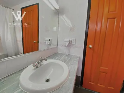 a bathroom with a white sink and a red door at Cozy Highlands Escape at Copthorne Cameron Highlands in Tanah Rata