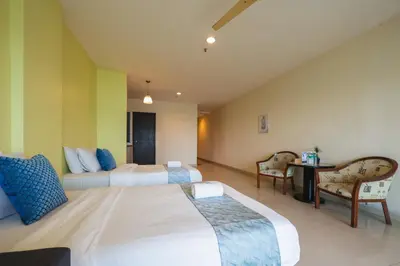 a bedroom with two beds and a table and chairs at Marina Island Lumut Homestay in Lumut
