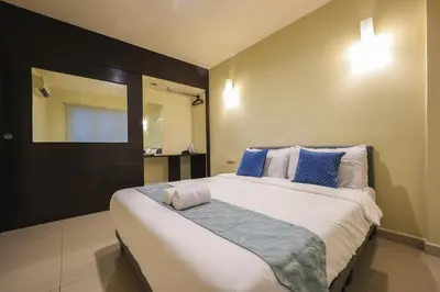 a bedroom with a large bed with blue and white pillows at Marina Island Lumut Homestay in Lumut