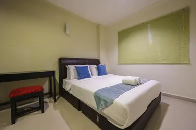 a bedroom with a bed with a chair and a window at Marina Island Lumut Homestay in Lumut